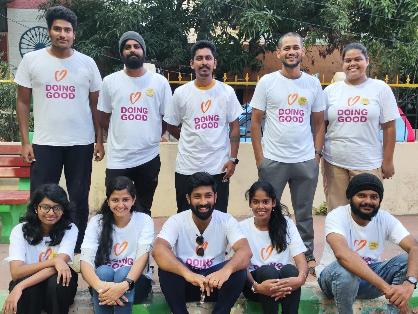 A group of volunteers wearing matching t-shirts stands together outdoors